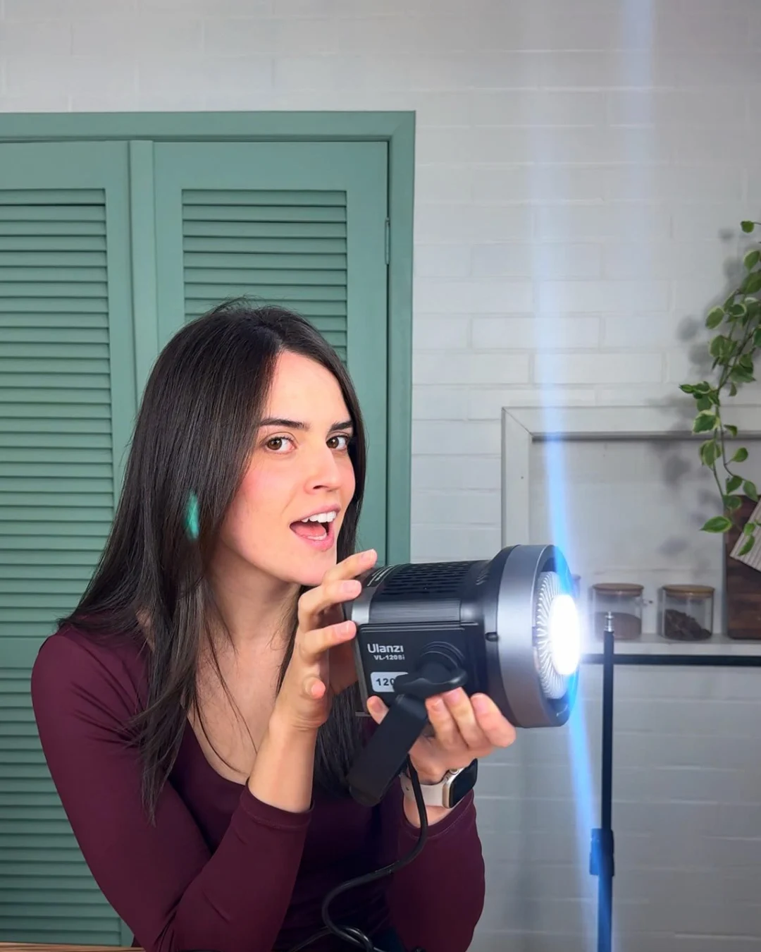 Elize com equipamento de iluminação nos bastidores de gravação