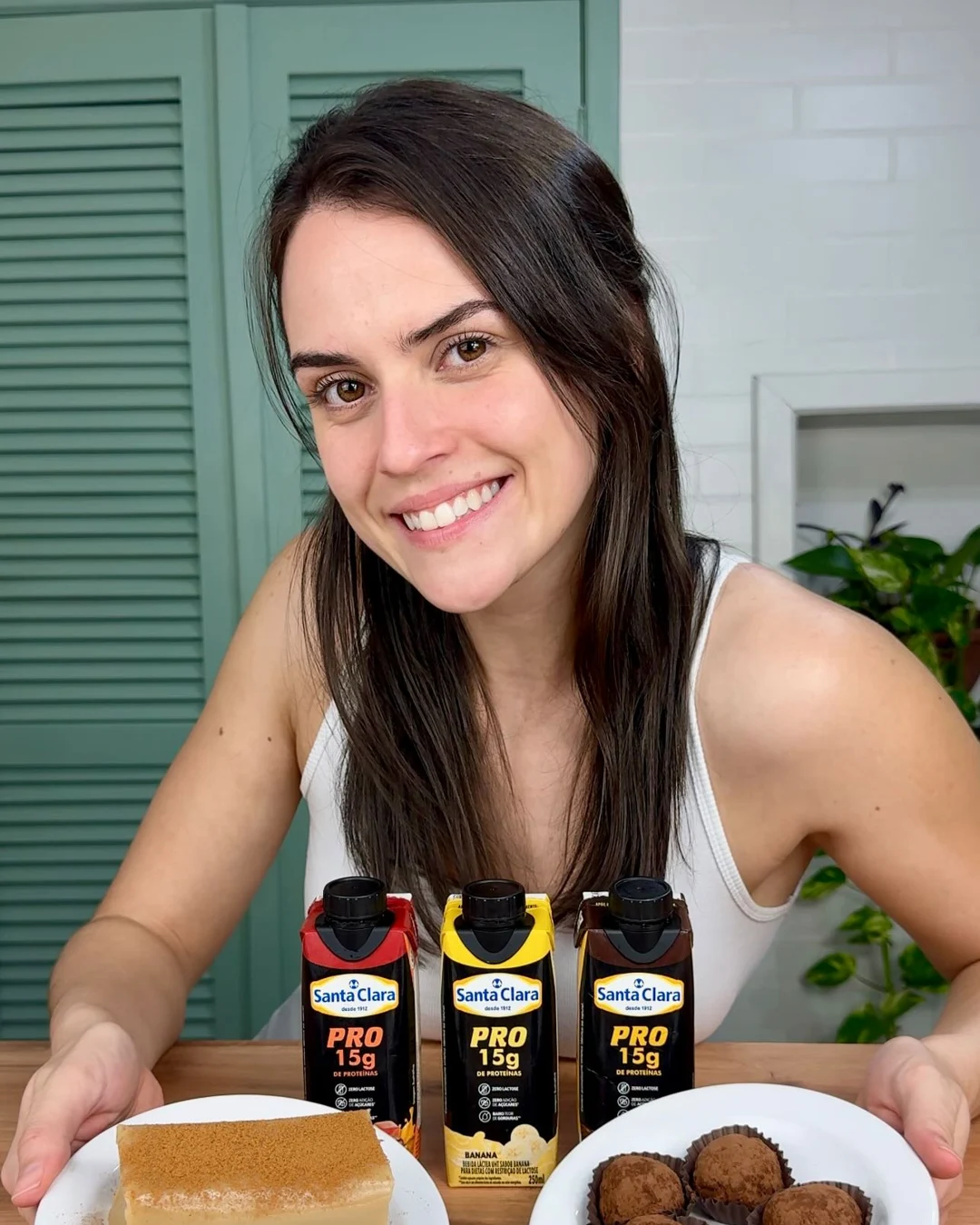 Elize com duas sobremesas e produtos Santa Clara PRO na bancada